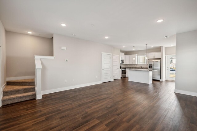 7026 Magnolia Crossings, Spring Hill, TN 37174 - unfurnished living room featuring baseboards, recessed lighting, and dark wood-type flooring