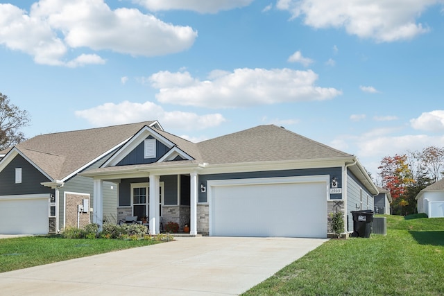 craftsman house featuring a garage and a front lawn