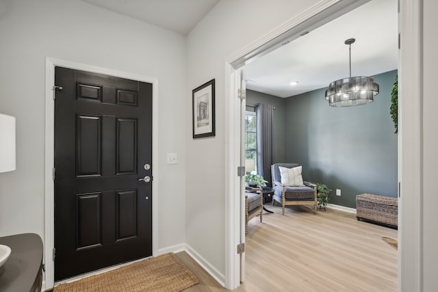 entrance foyer with light hardwood / wood-style flooring and a chandelier