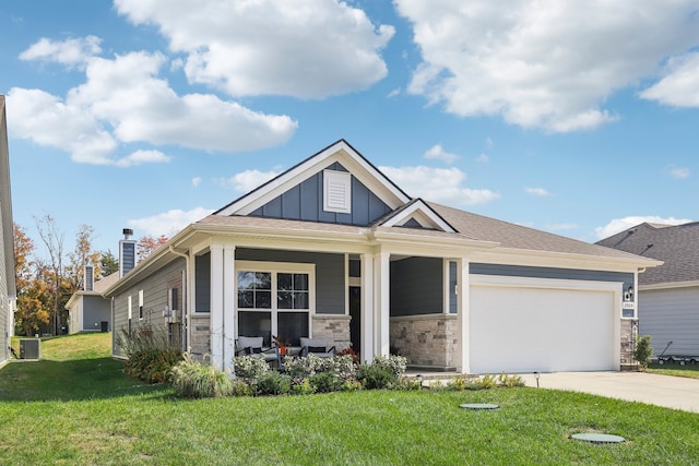 craftsman inspired home featuring a garage, a porch, a front lawn, and central AC