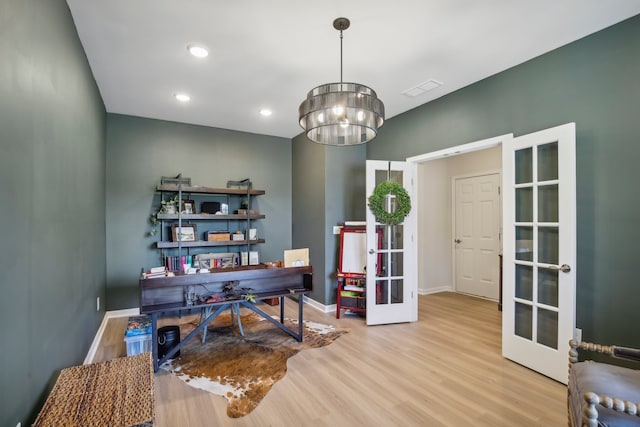 office area with a chandelier, french doors, and light hardwood / wood-style flooring