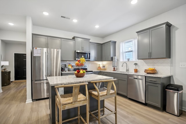 kitchen with light hardwood / wood-style flooring, sink, gray cabinets, and stainless steel appliances