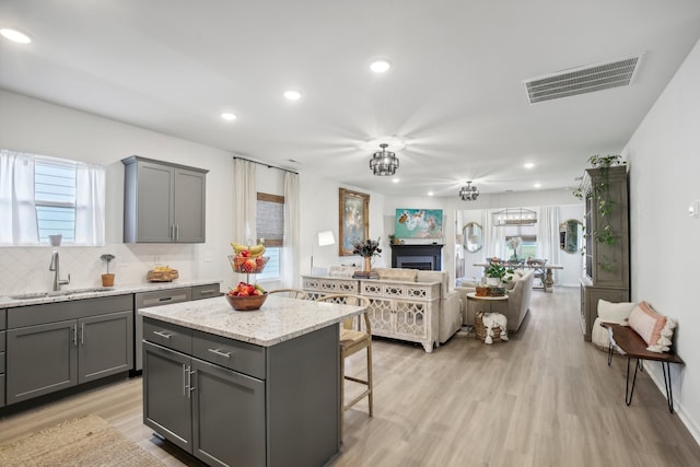 kitchen with gray cabinetry, sink, and a kitchen island