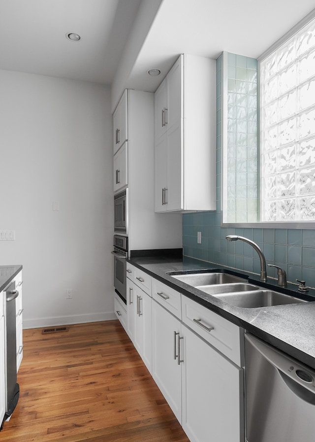 kitchen featuring white cabinetry, a wealth of natural light, appliances with stainless steel finishes, and sink