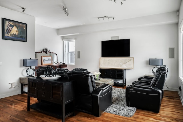 living room with wood-type flooring and track lighting