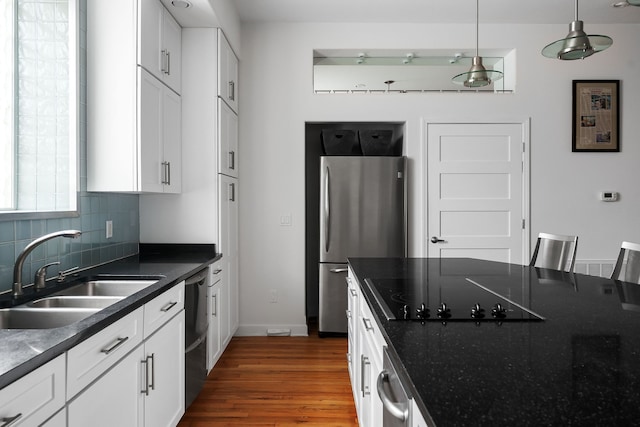 kitchen featuring sink, black appliances, pendant lighting, white cabinets, and dark wood-type flooring