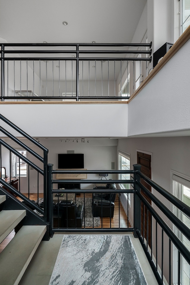 staircase with a towering ceiling and concrete floors