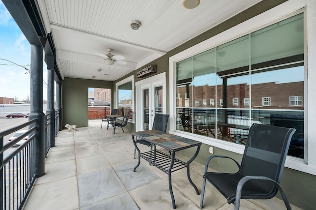 sunroom / solarium featuring ceiling fan, plenty of natural light, and french doors