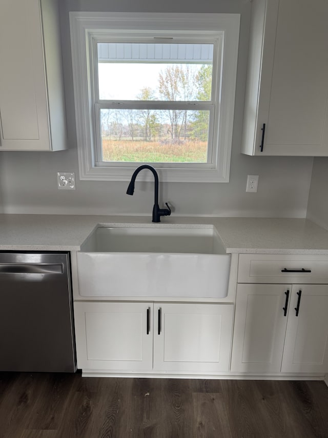 kitchen featuring dark hardwood / wood-style floors, light stone countertops, sink, white cabinets, and stainless steel dishwasher