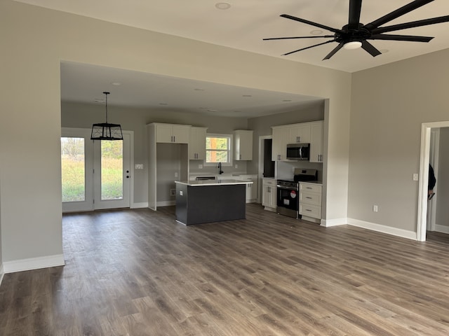 kitchen featuring stainless steel appliances, a wealth of natural light, white cabinetry, and a center island