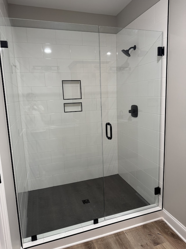 bathroom featuring hardwood / wood-style flooring and walk in shower