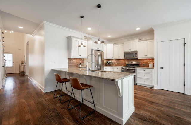 kitchen featuring kitchen peninsula, white cabinetry, pendant lighting, and appliances with stainless steel finishes