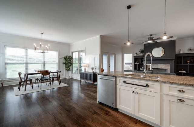 kitchen with dark hardwood / wood-style floors, white cabinetry, stainless steel dishwasher, and decorative light fixtures