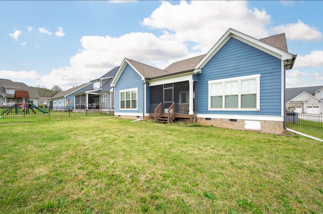 rear view of house featuring a sunroom, a playground, and a lawn