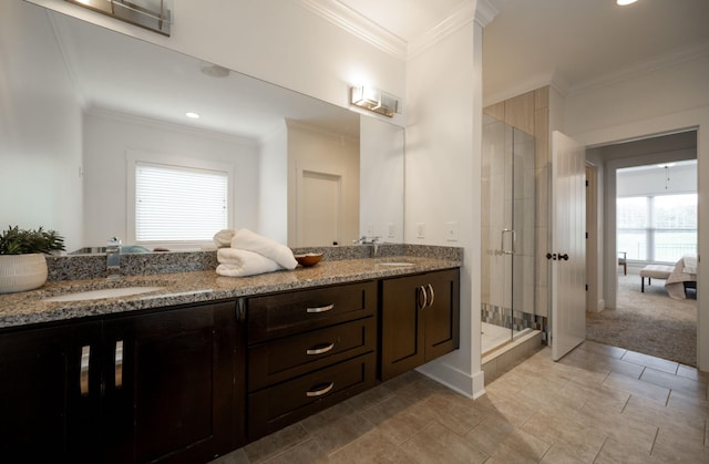 bathroom with vanity, a shower with door, and crown molding