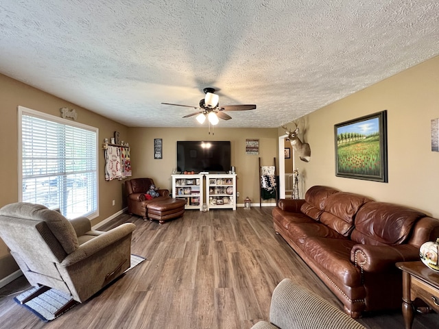 living room featuring a textured ceiling, wood-type flooring, and ceiling fan