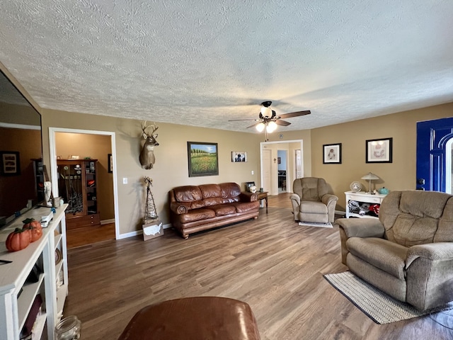 living room with ceiling fan, hardwood / wood-style floors, and a textured ceiling