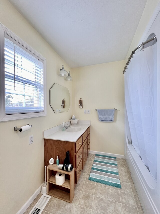 bathroom with tile patterned flooring, vanity, and shower / bath combo with shower curtain