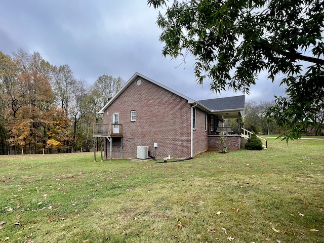 view of side of home with central AC and a lawn