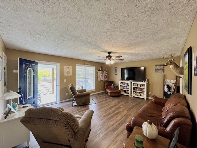 living room with ceiling fan, hardwood / wood-style flooring, and a textured ceiling