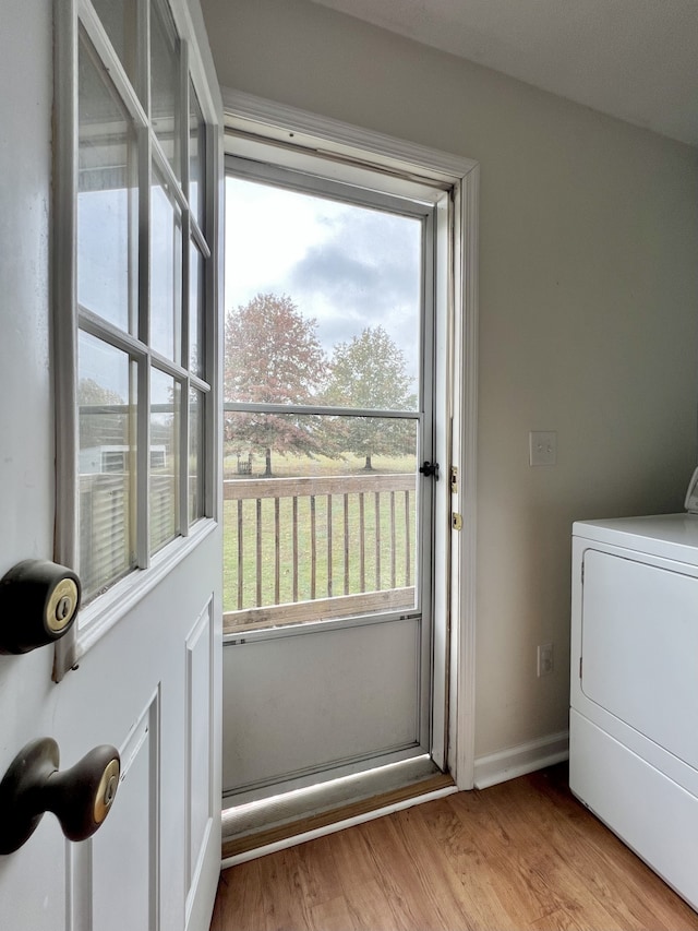 washroom with washer / clothes dryer and light hardwood / wood-style flooring