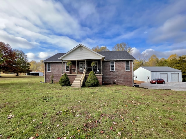 view of front facade with a porch, a garage, an outbuilding, and a front lawn