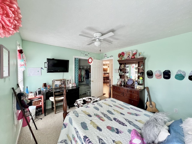 carpeted bedroom with ceiling fan, a closet, and a textured ceiling