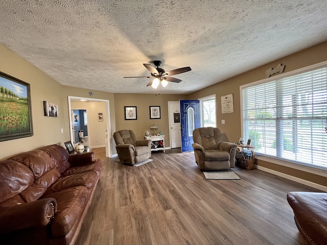 living room with ceiling fan, wood-type flooring, and a textured ceiling