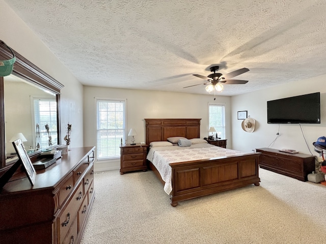 carpeted bedroom with a textured ceiling and ceiling fan