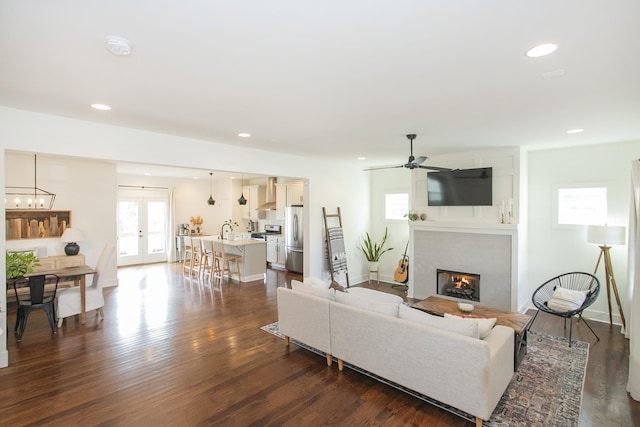 living room with ceiling fan, dark hardwood / wood-style floors, sink, and french doors