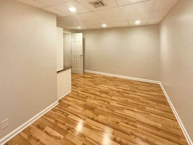 unfurnished room with a paneled ceiling and hardwood / wood-style flooring