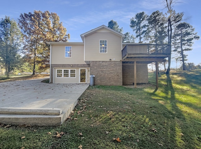 back of property with a deck, a yard, and a patio area