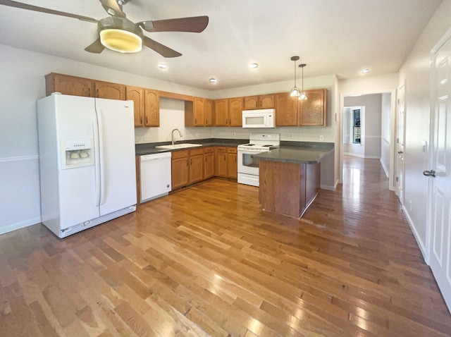 kitchen featuring white appliances, dark hardwood / wood-style floors, sink, and pendant lighting