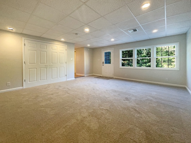 carpeted empty room with a paneled ceiling