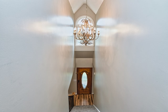 interior space featuring hardwood / wood-style flooring, vaulted ceiling, and an inviting chandelier