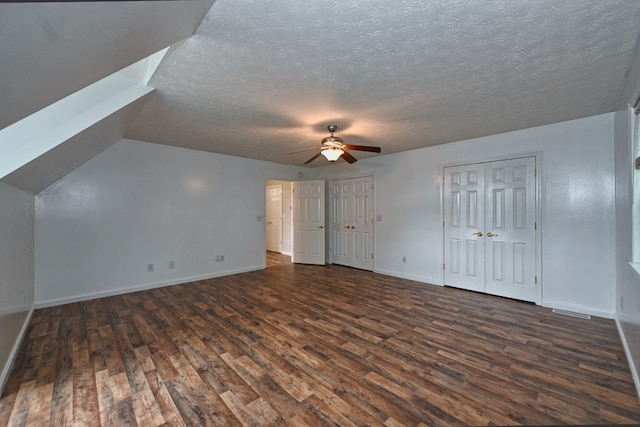 bonus room featuring ceiling fan, a textured ceiling, and dark hardwood / wood-style floors