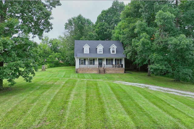 cape cod home with a porch and a front lawn