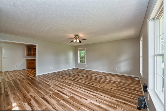 empty room featuring a textured ceiling, hardwood / wood-style flooring, and ceiling fan