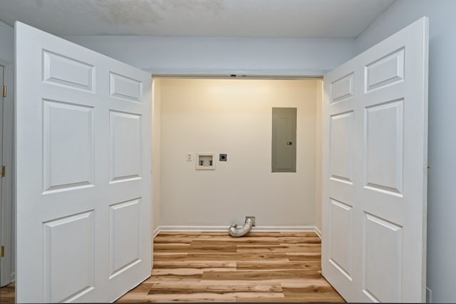 clothes washing area featuring electric panel, light hardwood / wood-style floors, hookup for a washing machine, and hookup for an electric dryer