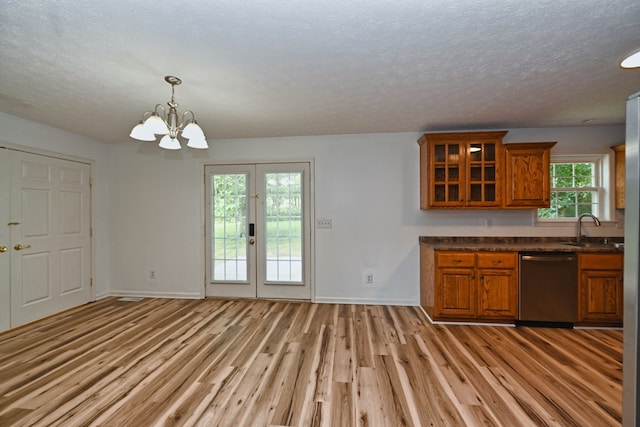 kitchen with light hardwood / wood-style floors, an inviting chandelier, sink, stainless steel dishwasher, and decorative light fixtures