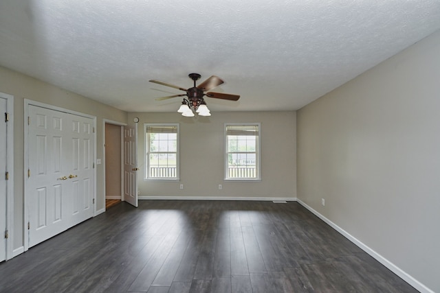 spare room with a textured ceiling, dark hardwood / wood-style floors, and ceiling fan