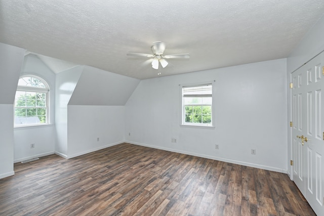 additional living space with a wealth of natural light, dark wood-type flooring, ceiling fan, and vaulted ceiling