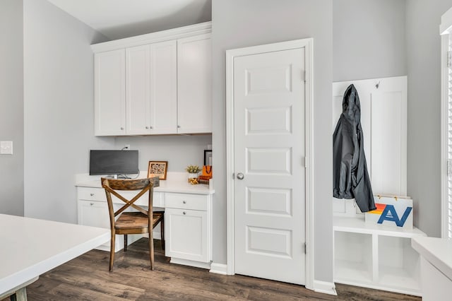 interior space with dark wood-type flooring and built in desk