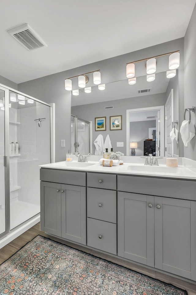 bathroom with vanity, wood-type flooring, and a shower with shower door