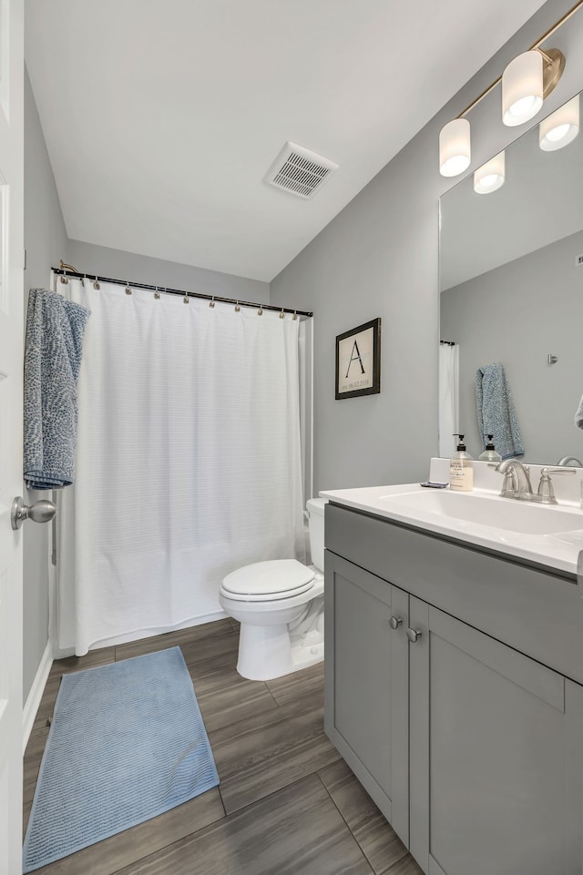 bathroom with hardwood / wood-style floors, vanity, and toilet