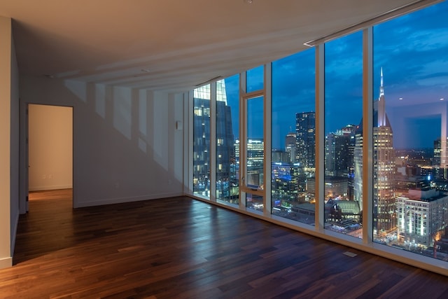 spare room featuring dark wood-type flooring and expansive windows