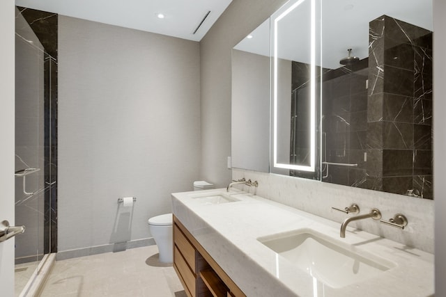 bathroom featuring a tile shower, vanity, tile patterned floors, and toilet