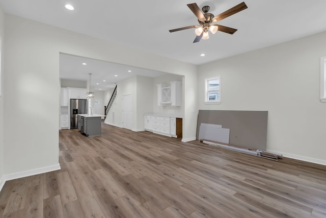 unfurnished living room with light hardwood / wood-style floors and ceiling fan