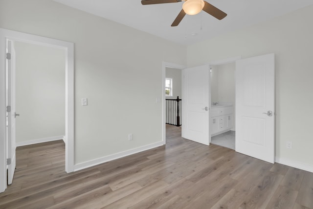 unfurnished bedroom with ensuite bathroom, ceiling fan, and light wood-type flooring