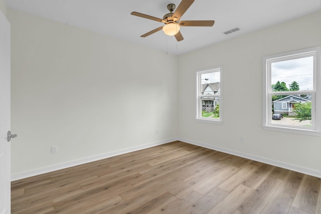 unfurnished room featuring light wood-type flooring, a wealth of natural light, and ceiling fan